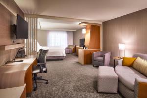 a hotel room with a bed and a couch at Courtyard by Marriott Salt Lake City Downtown in Salt Lake City +32 photos