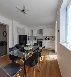 a dining room and kitchen with a table and chairs at 4 Bedroom 2 Bathroom House - Free parking in Ponders End