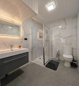 a bathroom with a shower and a toilet and a sink at 4 Bedroom 2 Bathroom House - Free parking in Ponders End