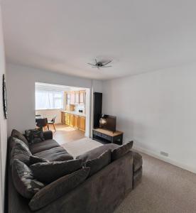 a living room with a large couch and a television at 4 Bedroom 2 Bathroom House - Free parking in Ponders End