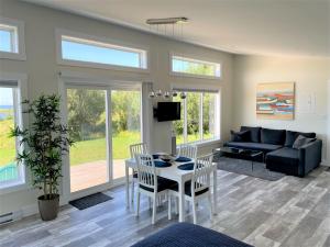 a living room with a couch and a table and chairs at Colindale Beach Villas -- MIni Villas in Port Hood