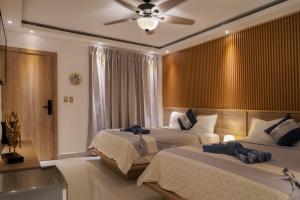 巴亚希贝Soficu Hotel on the beach bayahibe的一间带两张床和吊扇的卧室