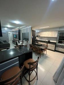 a kitchen and dining room with tables and chairs at Apartamento Porto Belo - Perequê in Perequê
