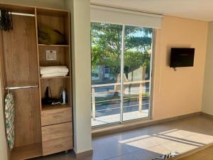 a room with a sliding glass door with a window at Hotel Payara Puerto Gaitán in Puerto Gaitán