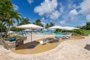 a swimming pool with umbrellas and chairs and a pool at The Buccaneer Beach & Golf Resort in Christiansted