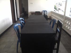 a long table with blue chairs in a room at Menginap di rumah tenun Astiti in Klungkung