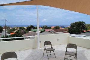 two chairs sitting on a balcony with an umbrella at My Shelter in Willemstad +24 photos