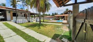 a house with a fence and a yard at Casa Ilha de Itaparica Bahia in Ilha de Itaparica