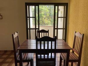 a dining room table with two chairs and a window at Casa grande, ampla, com 4 quartos e estacionamento in Ribeirão Preto