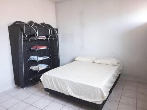 a bedroom with a bed and a black rack with towels at 18 - Apto com Estac Gratis e Conforto in Paragominas