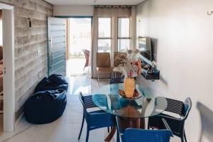 a dining room with a glass table and chairs at Casinha Azul Taiba in Taíba