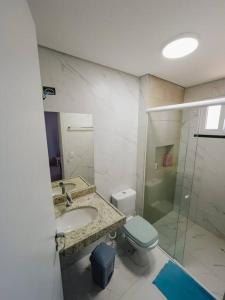 a bathroom with a sink and a toilet and a shower at Casinha Azul Taiba in Taíba