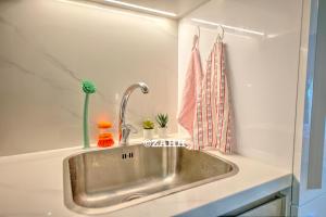 un évier de cuisine avec des plantes et un rideau de douche dans l'établissement Studio Haven, à Dubaï 11 autres photos