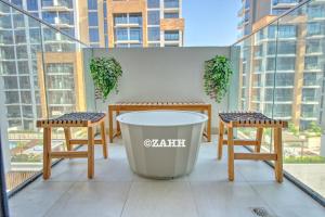 une table et deux chaises et une poubelle sur un balcon dans l'établissement Studio Haven, à Dubaï
