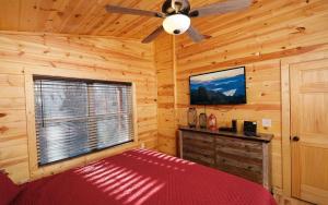 een slaapkamer met een bed en een plafondventilator bij Mountain Life in Sevierville +34 foto's