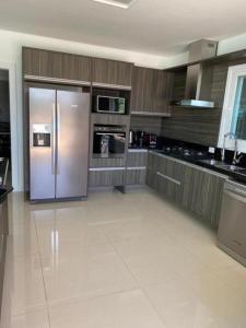 a large kitchen with a stainless steel refrigerator at Casa de Luxo no Condomínio Enseada in Xangri-lá +12 photos