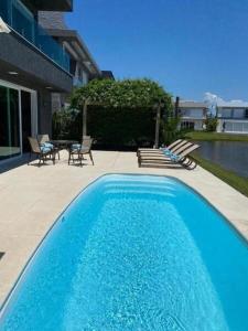 a large blue swimming pool next to a patio at Casa de Luxo no Condomínio Enseada in Xangri-lá