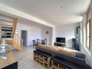 un soggiorno con un grande divano e una TV di Maison entre ville et plage avec cour jardin - FR-1-646-78 a Berck-sur-Mer