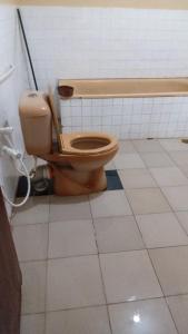a bathroom with a toilet in a tiled room at Kethmi Resort in Mapalagama