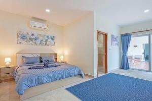 a bedroom with a bed with a blue comforter at Beautiful 5 Bedroom Luxury Pool Villa in Pattaya in Ban Huai Yai +60 photos