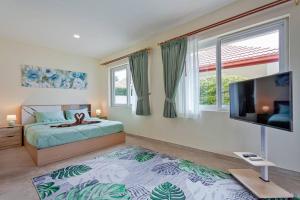 a bedroom with a bed and a flat screen tv at Beautiful 5 Bedroom Luxury Pool Villa in Pattaya in Ban Huai Yai