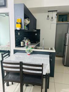 een keuken met een tafel, stoelen en een spoelbak bij Parc Regency Tiara Homestay in Johor Bahru