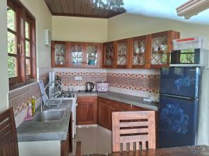 a kitchen with wooden cabinets and a blue refrigerator at GladWin Holiday Rental in Tawalantenna