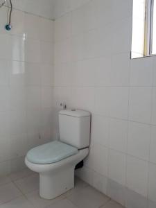 a bathroom with a white toilet with a blue seat at Room Had glaund flow with two guests in Nungwi