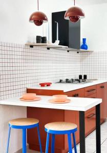 une cuisine avec deux tabourets et un comptoir blanc dans l'établissement Casa Décima - Recién Remodelada, à Hermosillo