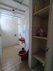 a bathroom with a red toilet and a sink at Anitas place in Port Dickson