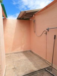 a room with a pink wall with a shower at Island Relax Retreat in Willemstad +1 photo