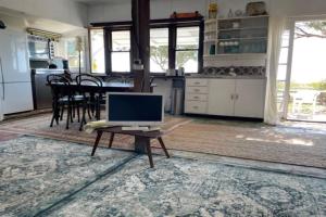 a computer monitor sitting on a table in a kitchen at Boathouse - Highest Hilltop On Oceanfront in Lancelin +13 photos