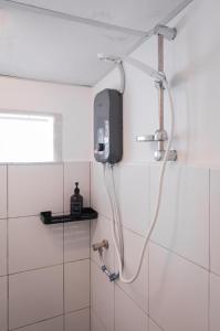 een douche in een badkamer met een tv aan de muur bij The Terraces by Aayu - 2 mins walk to Chulia Street in George Town +28 foto's