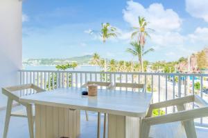 a table and chairs on a balcony with a view of the ocean at Beachfront Luxury Apartment 33 in Bang Rak Beach