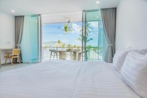 a bedroom with a bed and a balcony with a table at Beachfront Luxury Apartment 33 in Bang Rak Beach +25 photos
