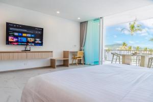 a bedroom with a large white bed and a balcony at Beachfront Luxury Apartment 33 in Bang Rak Beach