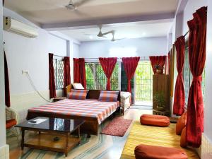 a living room with a couch and a table at Chaiti Eco Homestay- Santiniketan Bolpur in Bolpur +31 photos