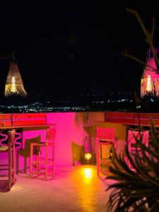 a room with a table and chairs at night at Santacruz Surf Camp Morocco in Tamraght Ouzdar +36 photos