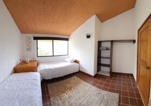 Un dormitorio con dos camas y una ventana. en Villa 25 La Rinconada Tequisquiapan, en Tequisquiapan