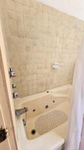y baño con bañera y cortina de ducha. en Villa 25 La Rinconada Tequisquiapan, en Tequisquiapan