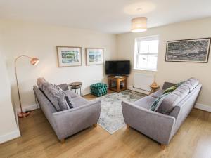 a living room with two couches and a tv at Crossing Cottage in Whitby