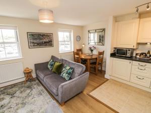 a living room with a couch and a kitchen at Crossing Cottage in Whitby