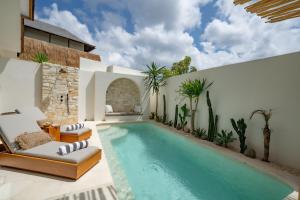 een buitenzwembad met 2 ligstoelen en een zwembad bij 7Seas Bingin in Uluwatu