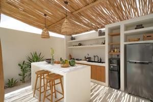 een keuken met een witte bar en een koelkast bij 7Seas Bingin in Uluwatu +69 foto's