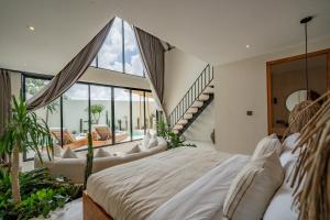 een slaapkamer met een groot bed en een trap bij 7Seas Bingin in Uluwatu