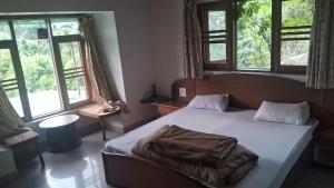 a bedroom with a bed with a blanket on it at Experto The Greens in Nainital