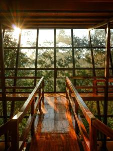 a room with a balcony with a view of trees at Ecoterra Inka Lodge Shared Rooms in Quillabamba