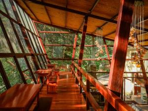 a room with wooden tables and benches in a tree house at Ecoterra Inka Lodge Shared Rooms in Quillabamba