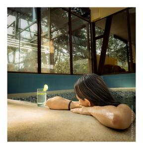 a young girl laying on the floor next to a glass of water at Ecoterra Inka Lodge Shared Rooms in Quillabamba