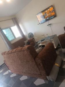 sala de estar con sofá marrón y TV en Résidence Meublée Smart 2, en Man